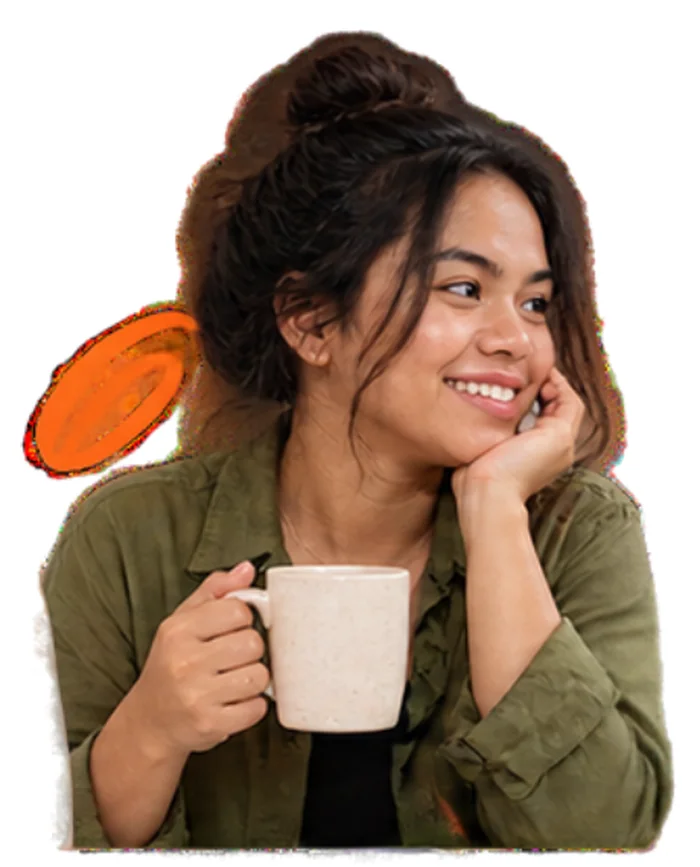 A founder in a green shirt holding a coffee mug and smiling